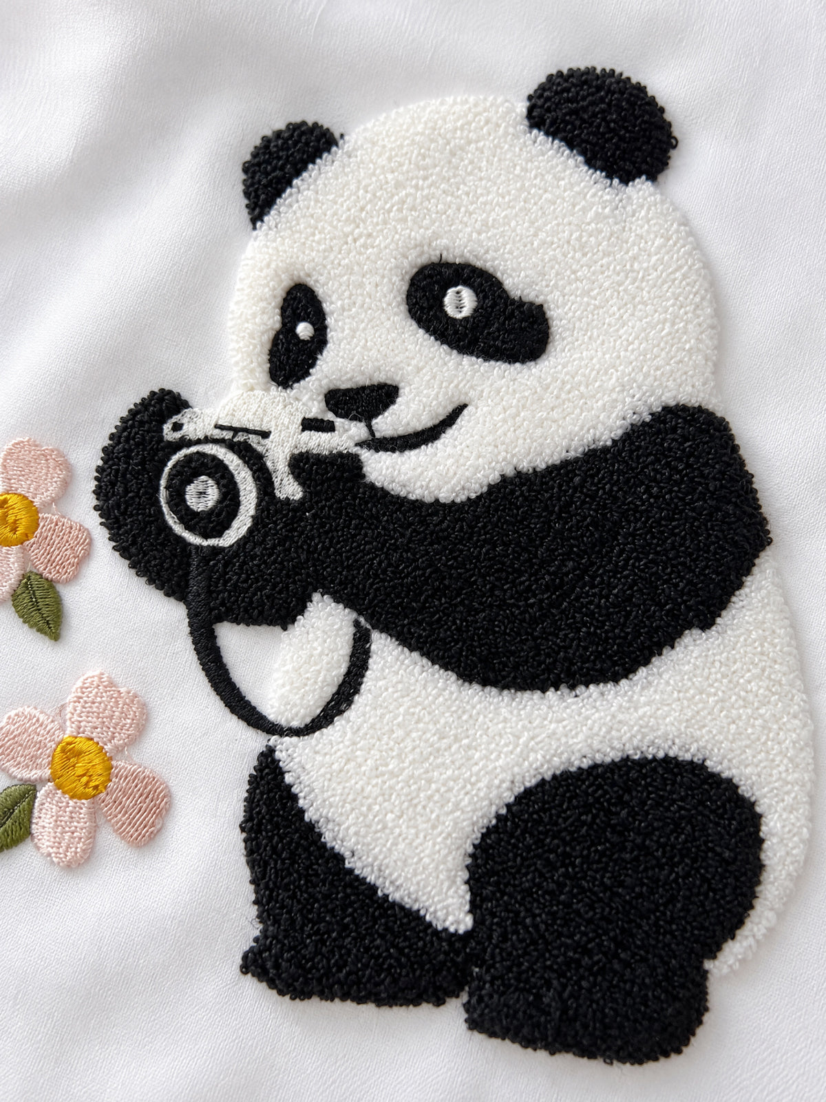Fotoğrafçı Panda punch nakış yakın çekim: fotoğraf makinesi tutan kabarık dokulu panda ve pembe çiçekler